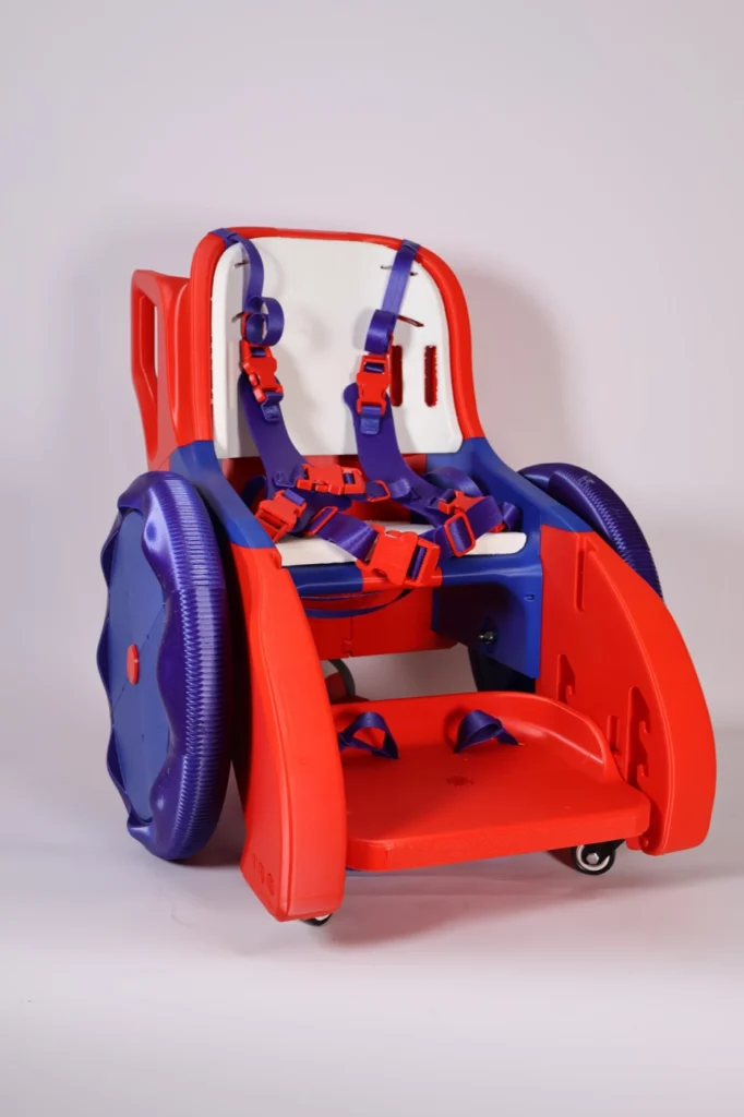 Toddler Mobility Trainer em vermelho e roxo, cadeira infantil de plástico impressa em 3D com cinto de cinco pontos, rodas grandes e apoio para os pés, sobre fundo branco