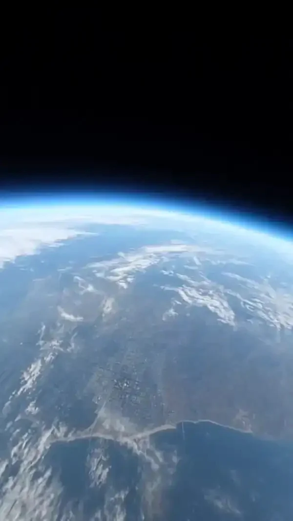 Quadro vertical de exemplo da biblioteca de efeitos: a Terra vista da órbita, com a linha azul da atmosfera e nuvens sobre o litoral