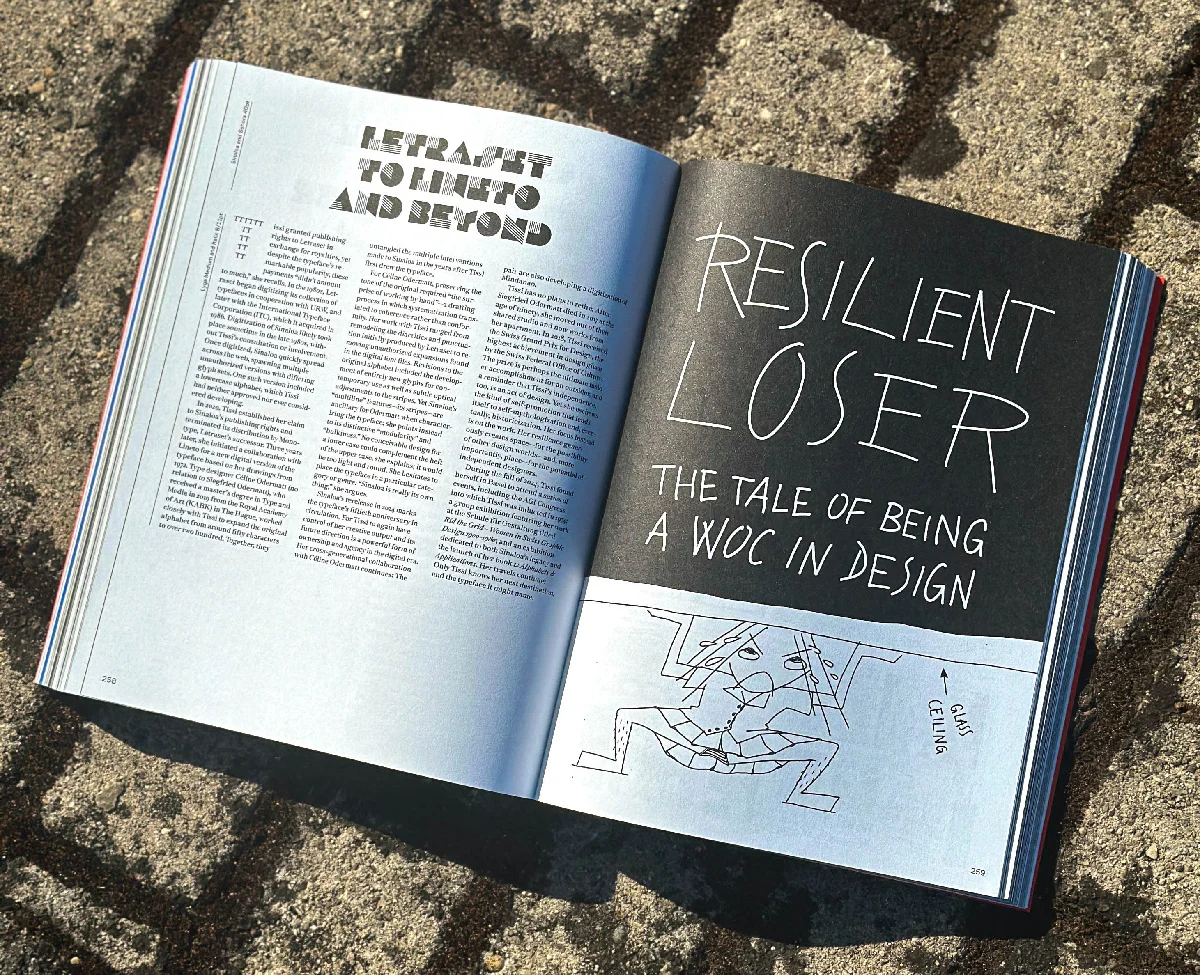 Livro aberto numa página preta com o título Resilient Loser: the tale of being a WOC in design, em letras desenhadas à mão