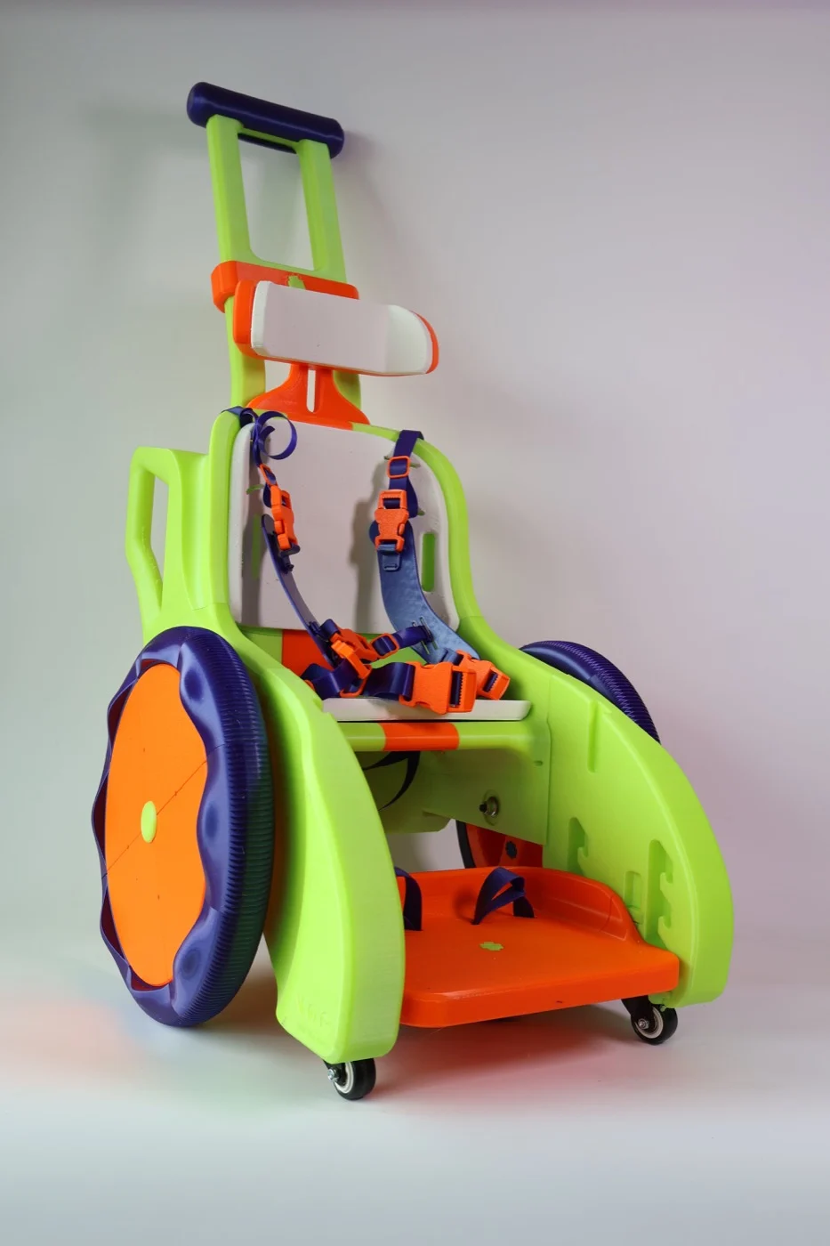 Versão verde e laranja do Toddler Mobility Trainer com alça de empurrar e apoio de cabeça