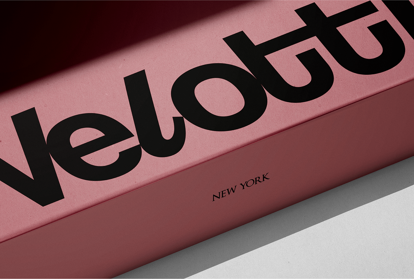 Caixa rosa com o logotipo Velotti em preto e a inscrição New York