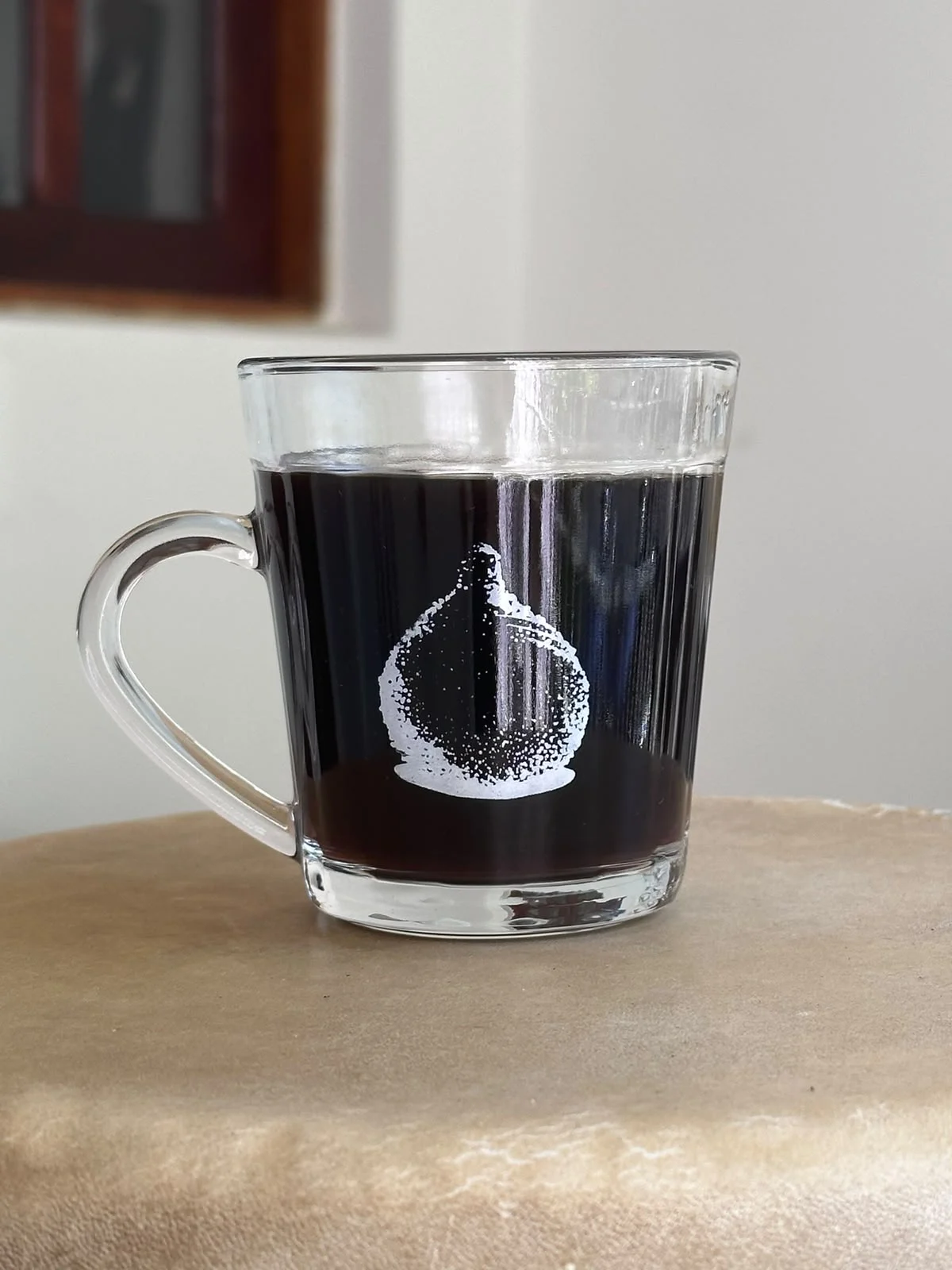 Caneca de vidro com café e um croquete impresso em branco